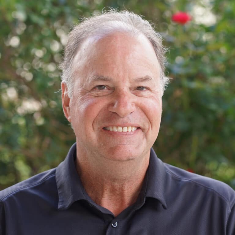 Smiling older man in navy shirt outdoors