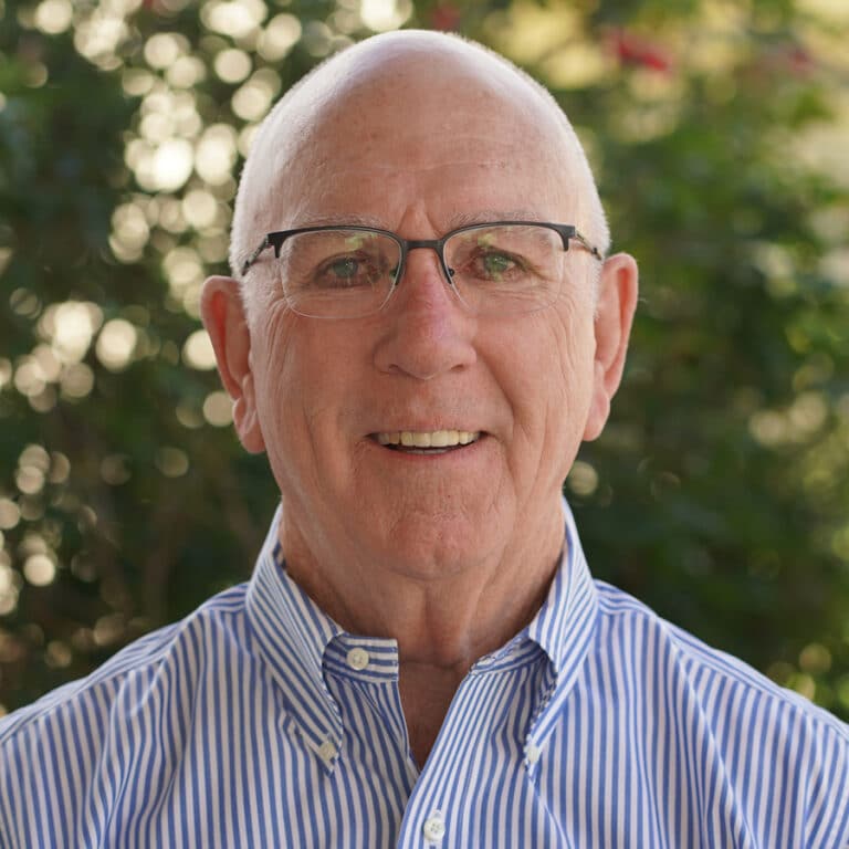 Smiling elderly man with glasses outdoors