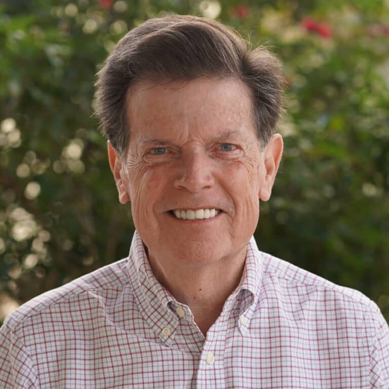 Smiling older man in checkered shirt outdoors