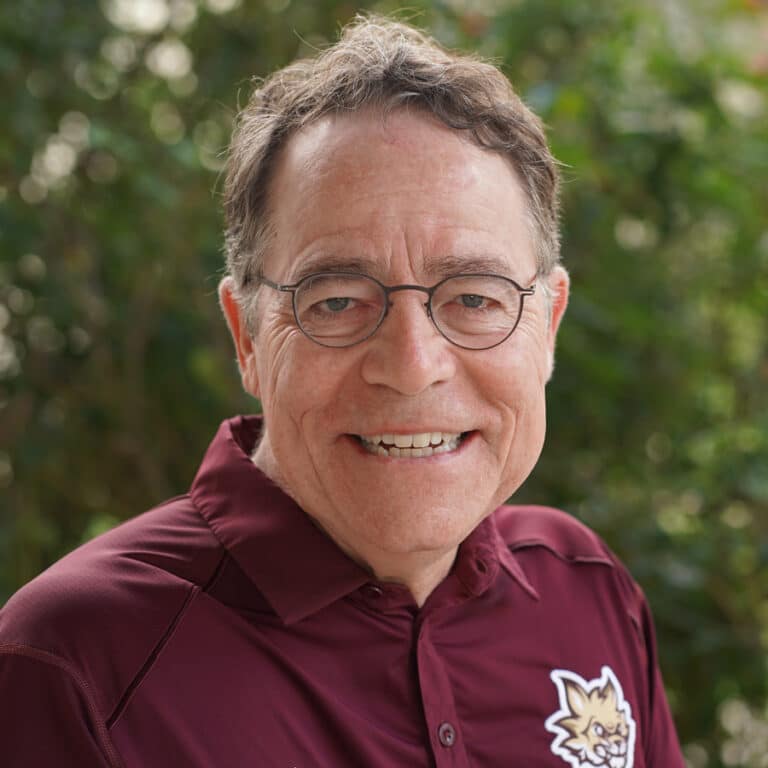 Smiling older man in maroon polo outdoors