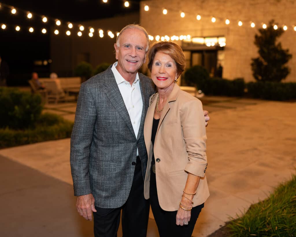 Smiling older couple under string lights at night