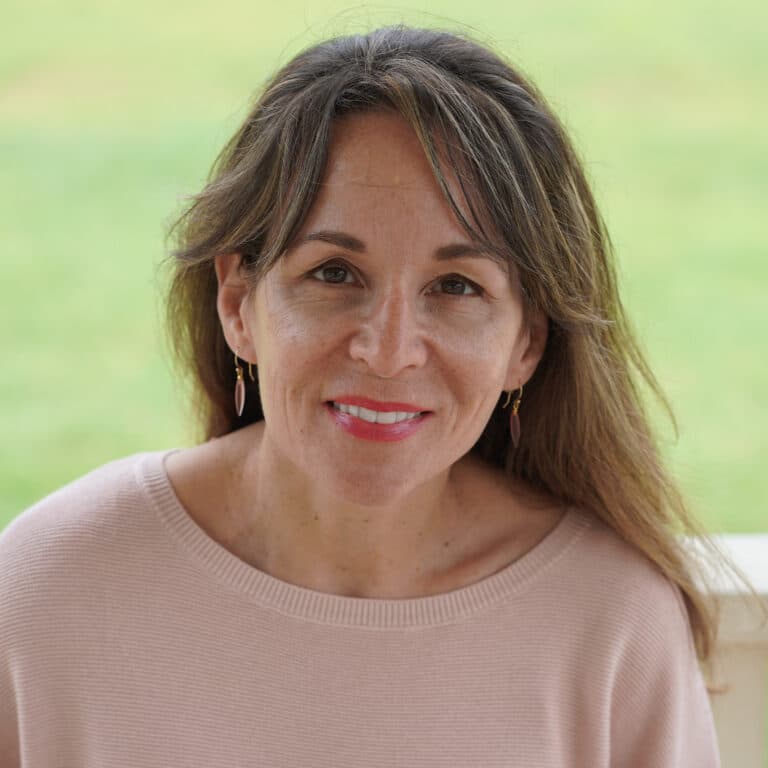 Smiling woman with brown hair against green background