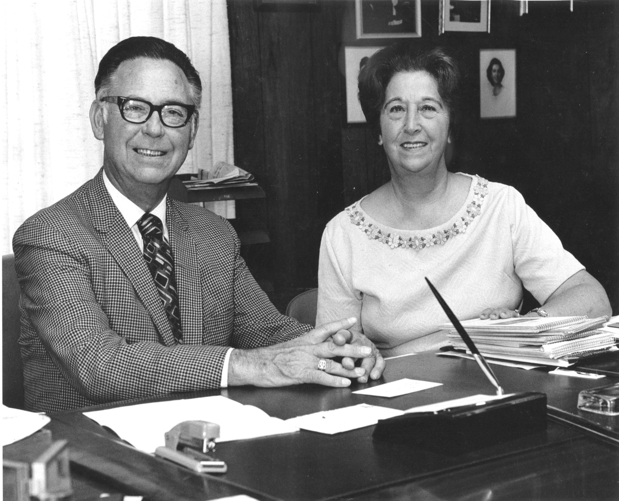 Ed and Marge Bridges seated together at a desk in an office.