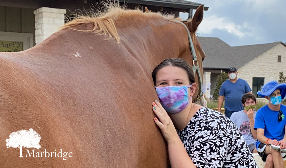 A Marbridge resident happily hugging a horse.