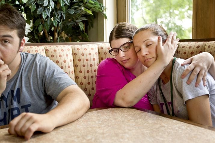 Three people sitting at a booth in The Village dining room.